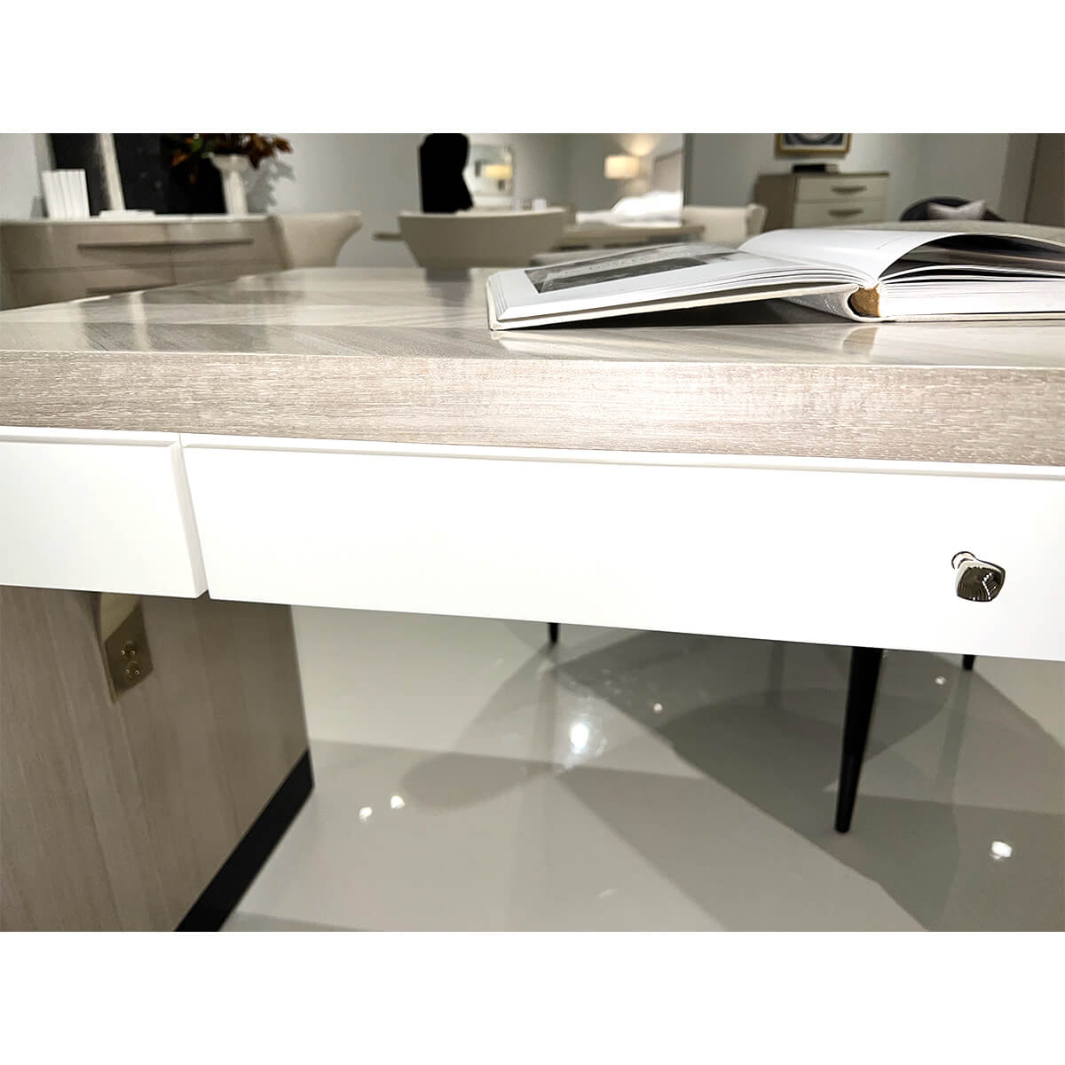 Herringbone desk focusing on white drawer and books.