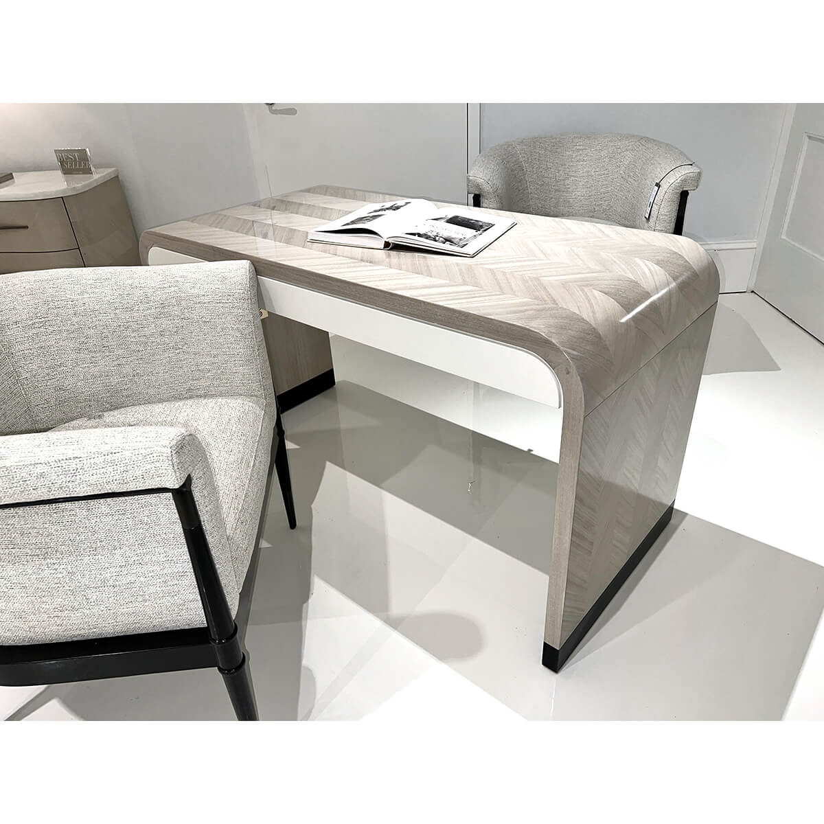 Herringbone desk in chic room with two armchairs.