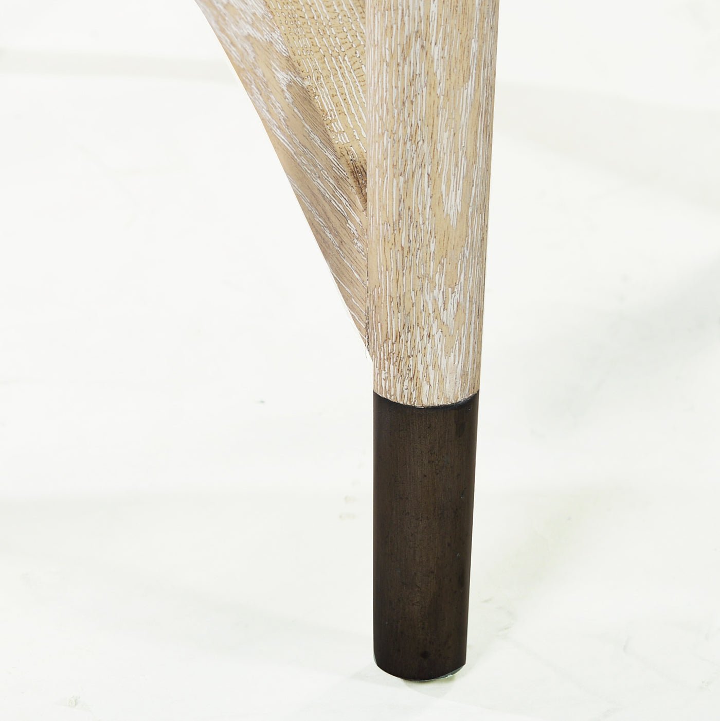 Close-up of round side table leg with dark base.
