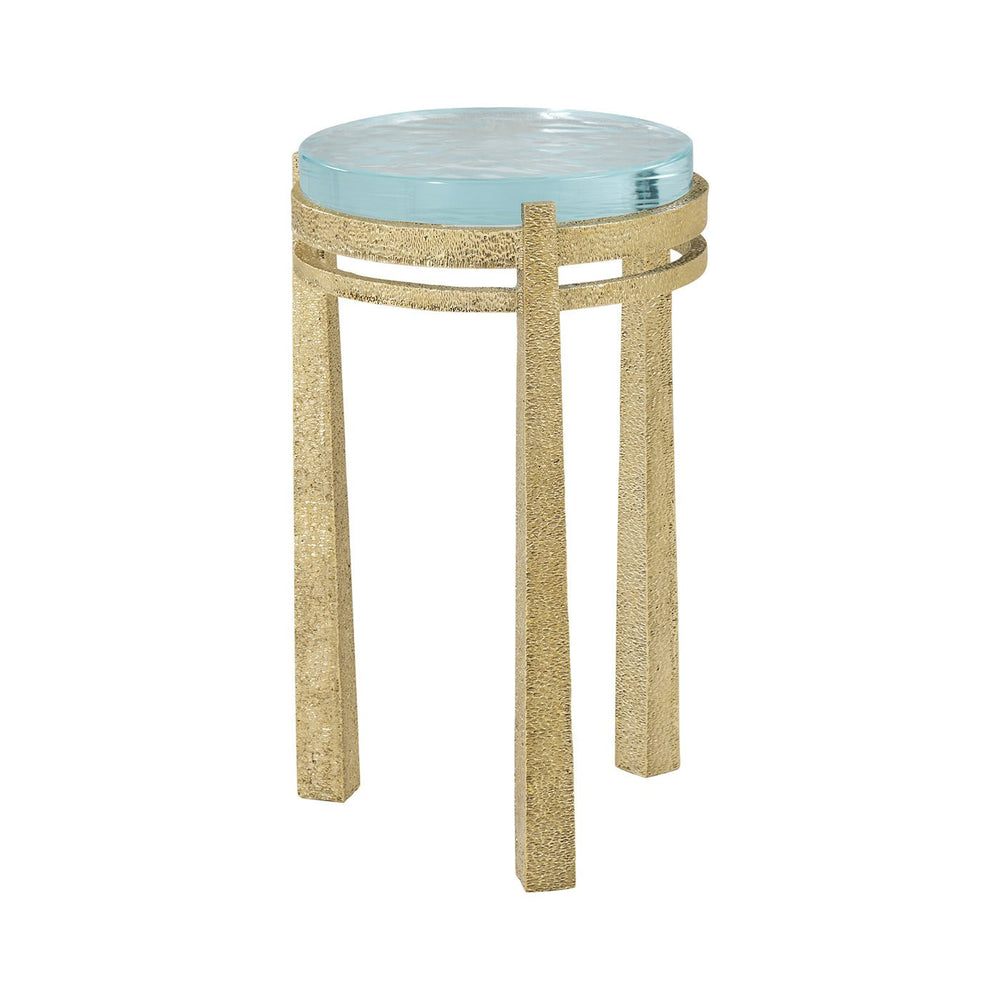 Gold accent table with glass top, artistic design.