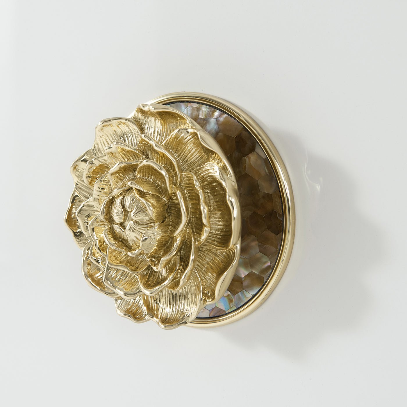 Detailed view of gold floral knob on sideboard.
