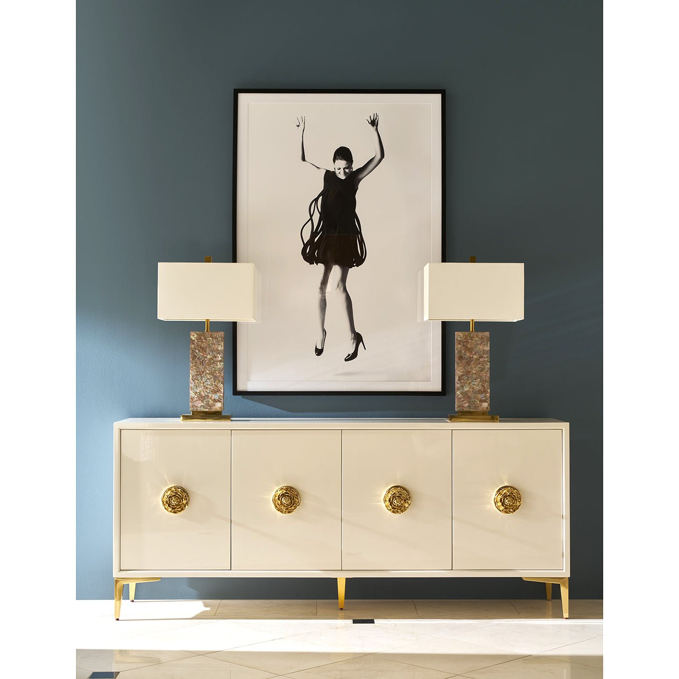 Styled white sideboard with gold accents in room.