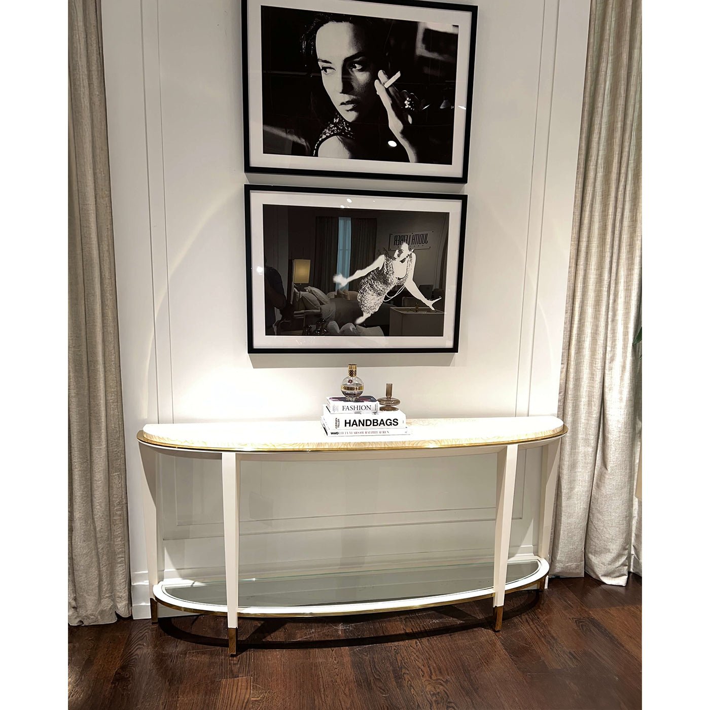Demilune console table styled beneath framed photographs.