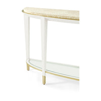 Corner detail of demilune console table with gold accents.