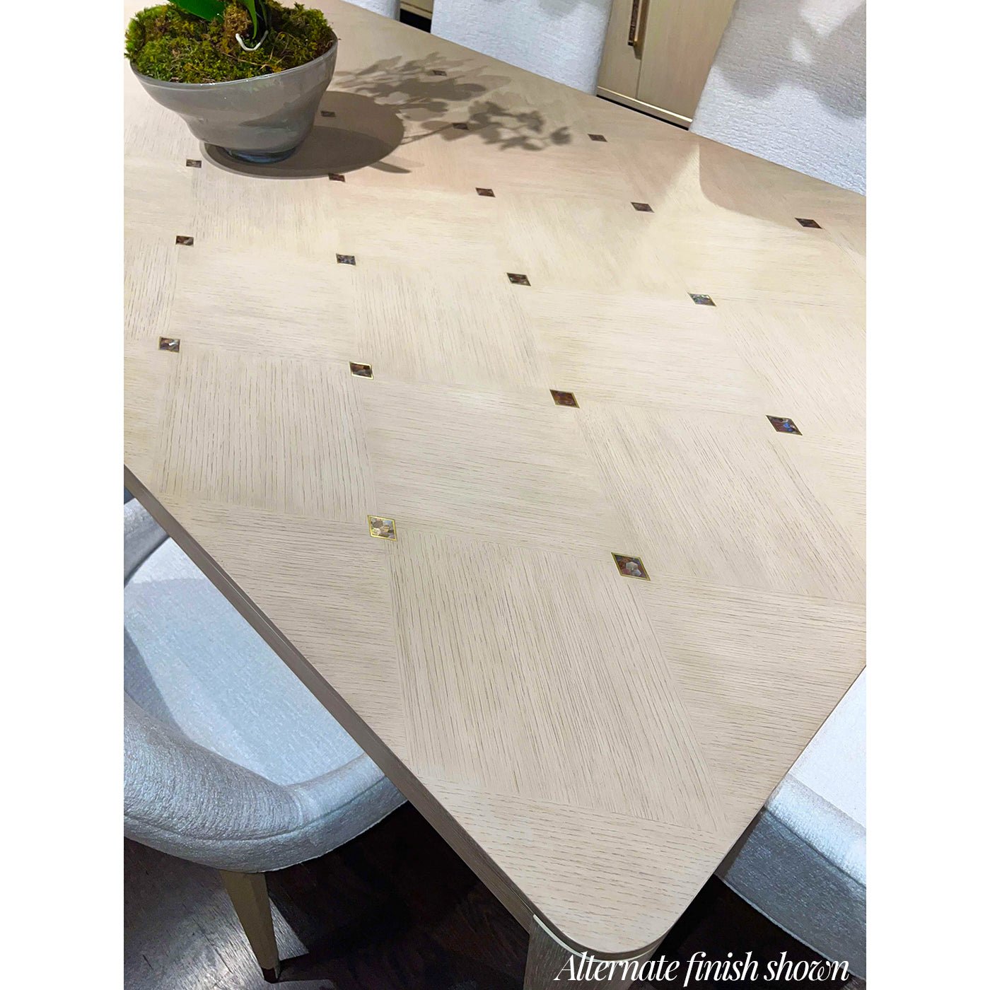 Smooth dining table surface with small square inlays.