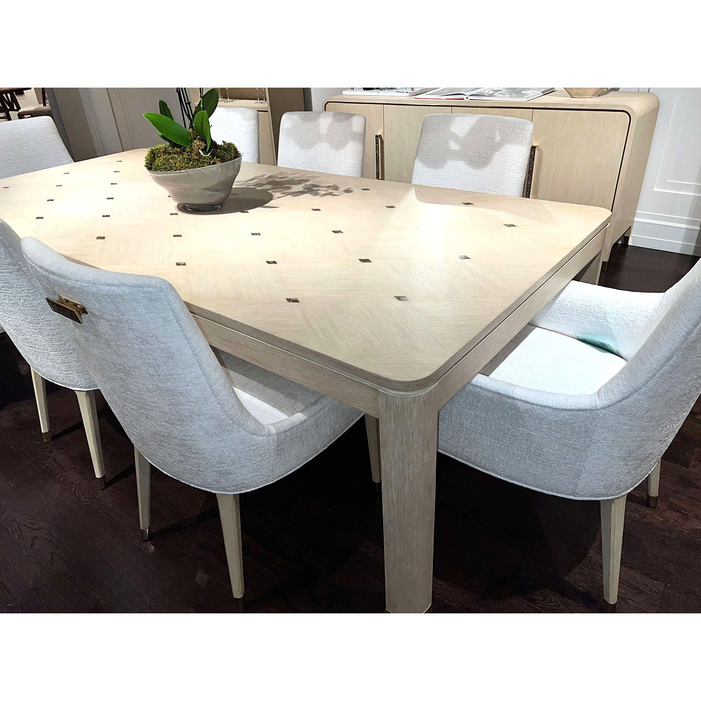 Close-up dining table top with white chairs around.