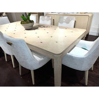 Close-up dining table top with white chairs around.