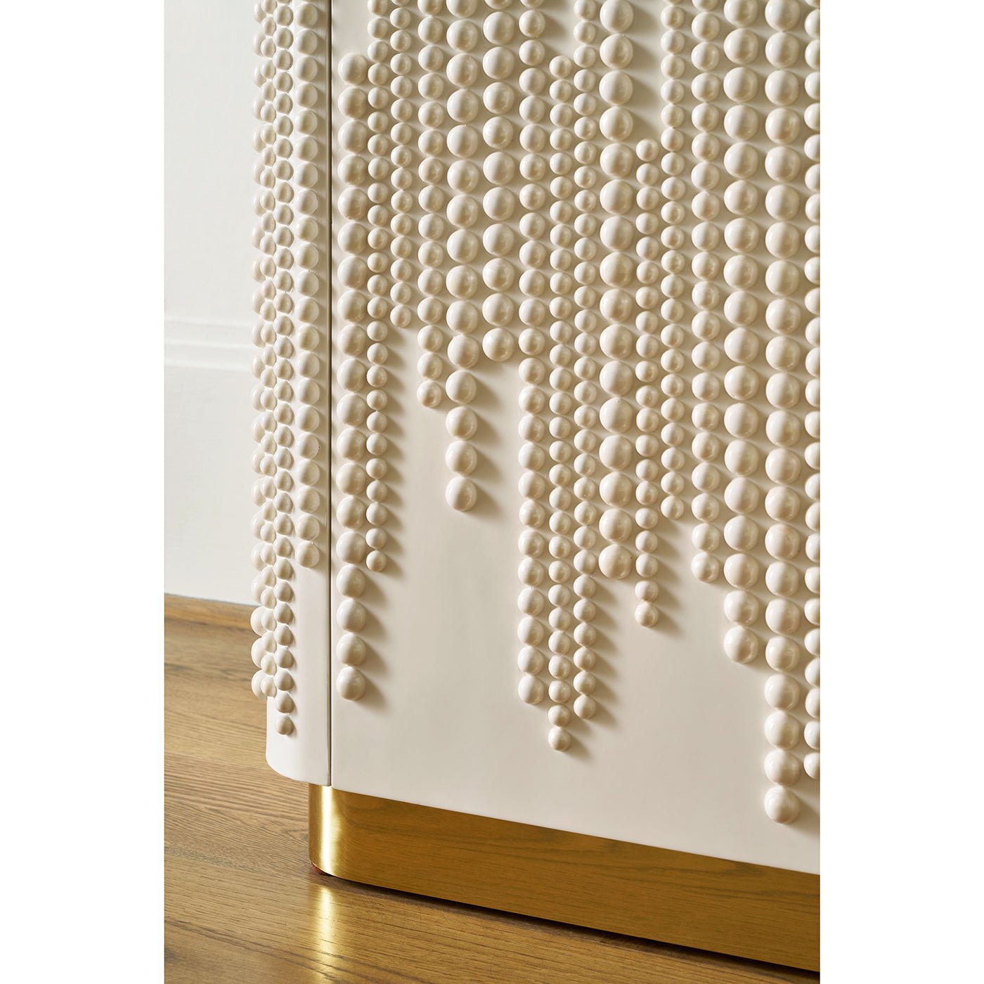 Bottom detail of bookcase with gold accent and texture.