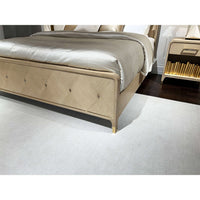 Footboard of Hollywood Regency king bed, close-up, floor rug visible.