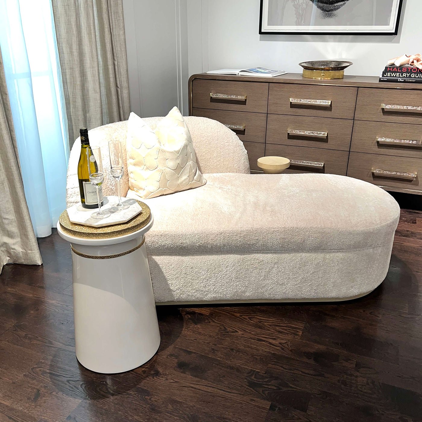 Accent table beside chaise, holding wine and glasses.