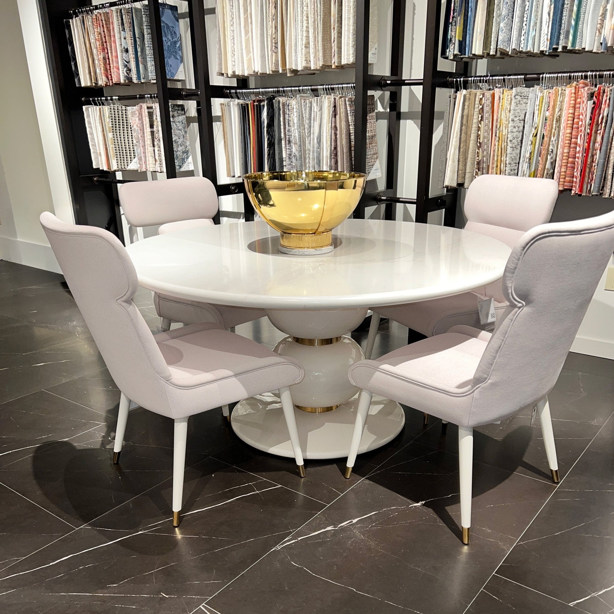 Dining table with gold bowl and chairs, showroom display.