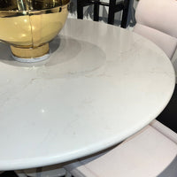Close-up of marble-look tabletop with gold bowl detail.