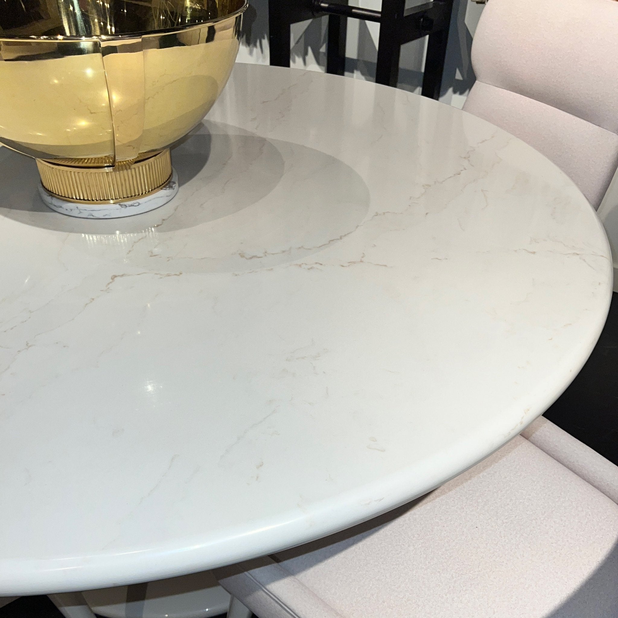 Close-up of marble-look tabletop with gold bowl detail.