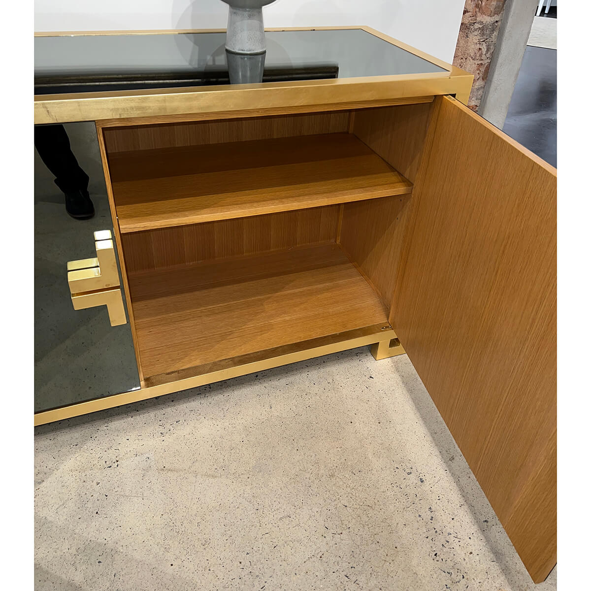 Inside of sideboard showing wooden shelves, door open.