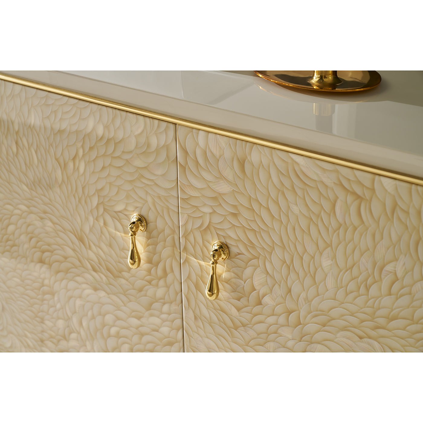 Detailed view of cabinet surface with gold trim and handles.