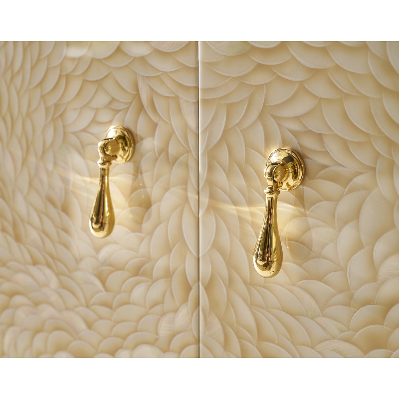 Close-up of cabinet's textured pattern and gold handles.