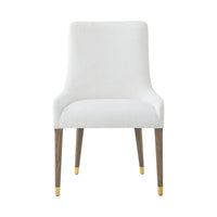 Front face of white dining chair with gold-tipped legs.