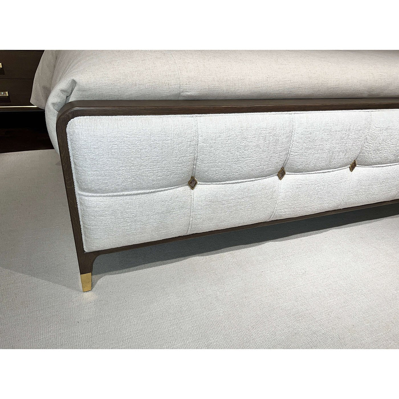 Footboard detail of the upholstered king bed with accents.