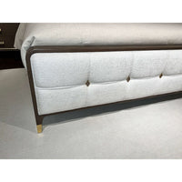 Footboard detail of the upholstered king bed with accents.