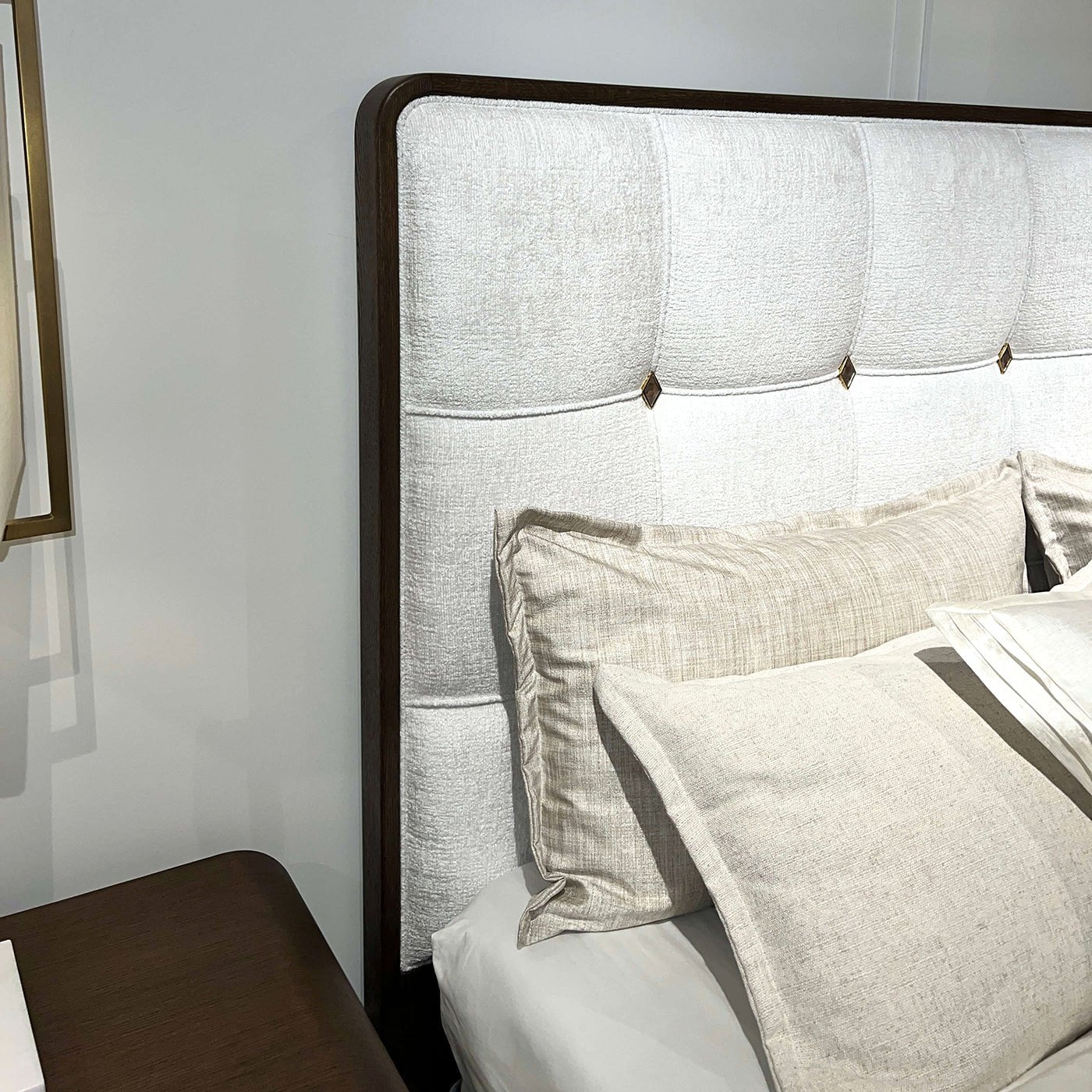 Headboard close-up emphasizing the upholstery and pillows.