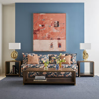 Styled living room with coffee table and floral sofa.