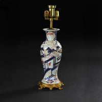 Imari pattern porcelain table lamp, dark background.