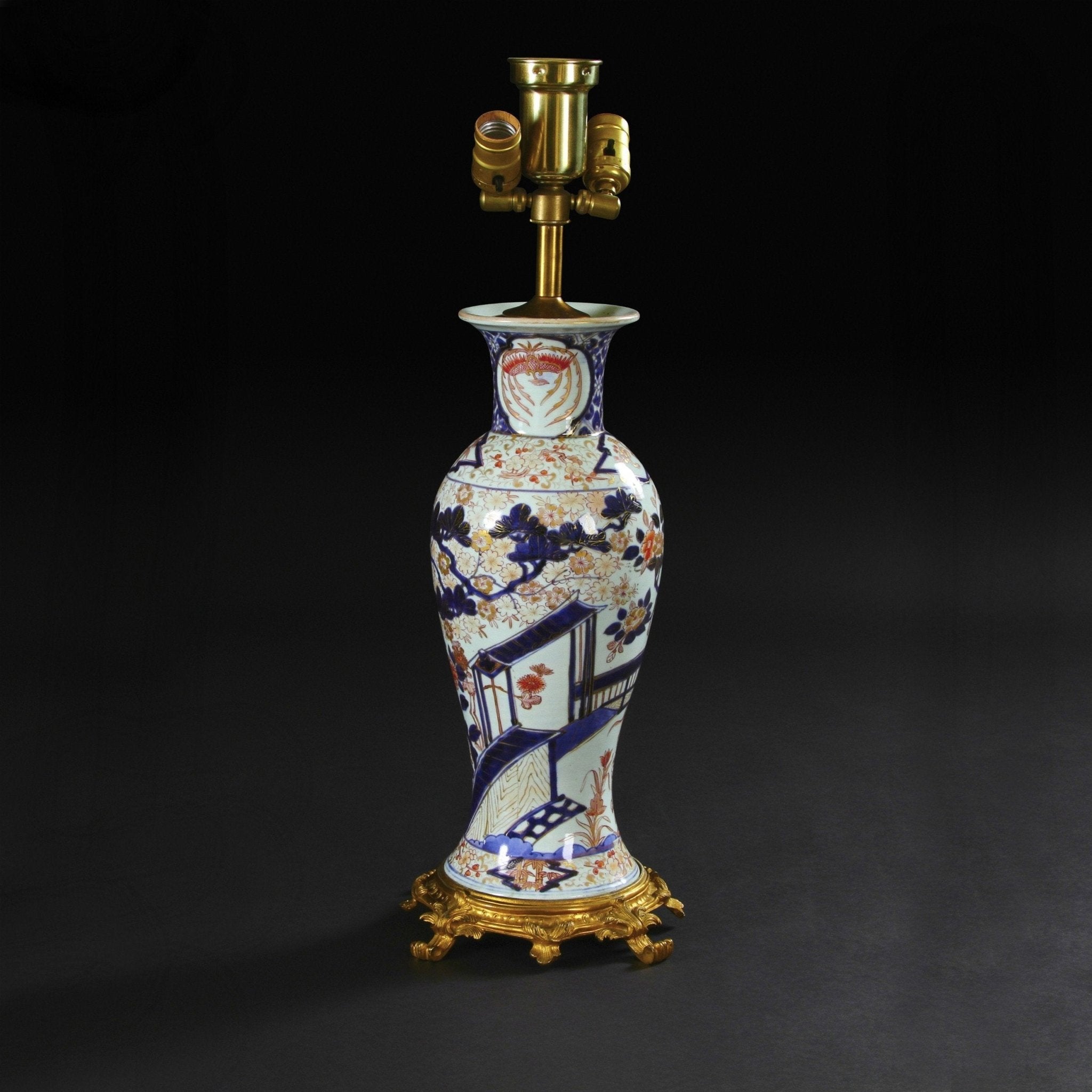 Imari pattern porcelain table lamp, dark background.