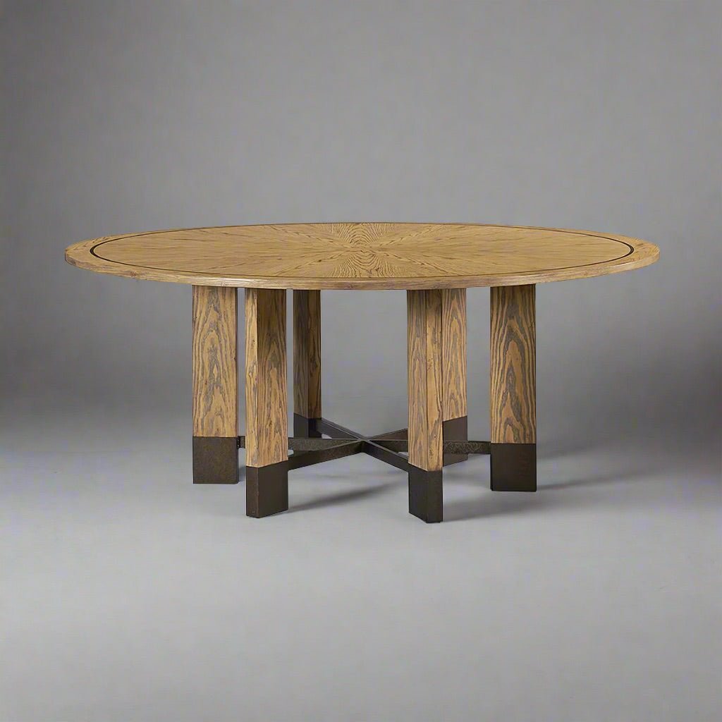 Industrial-style round dining table on grey background.
