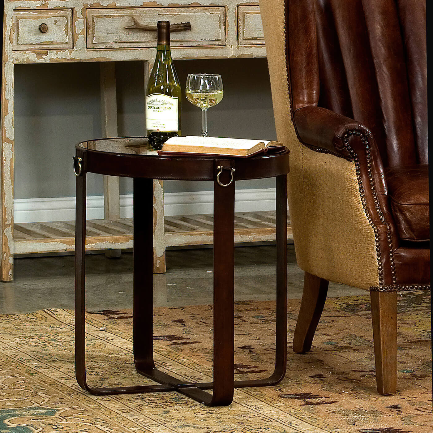 Round leather end table styled in rustic living room.