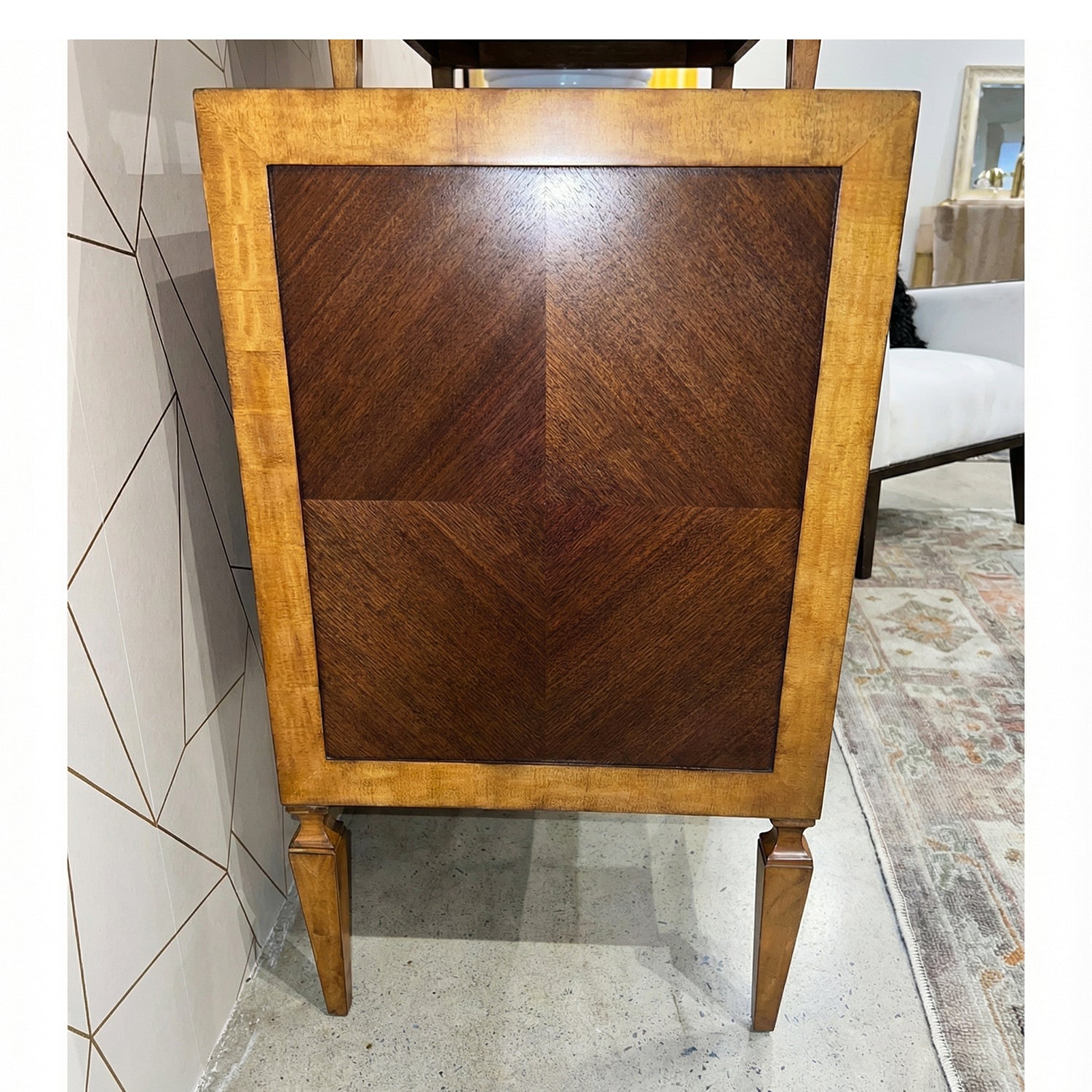 Side panel view of Italian nightstand, intricate veneer pattern.