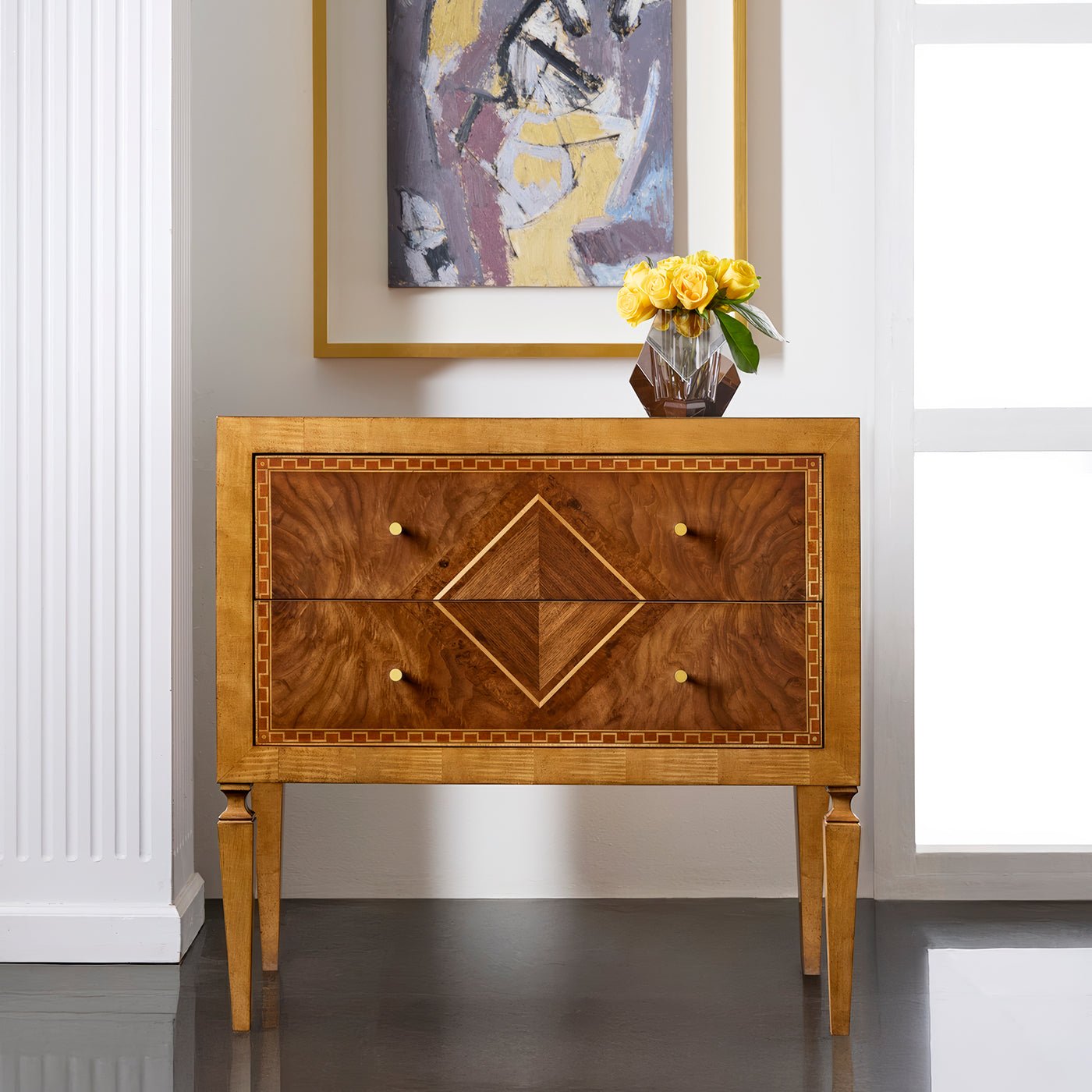 Nightstand in elegant room setting with abstract artwork.