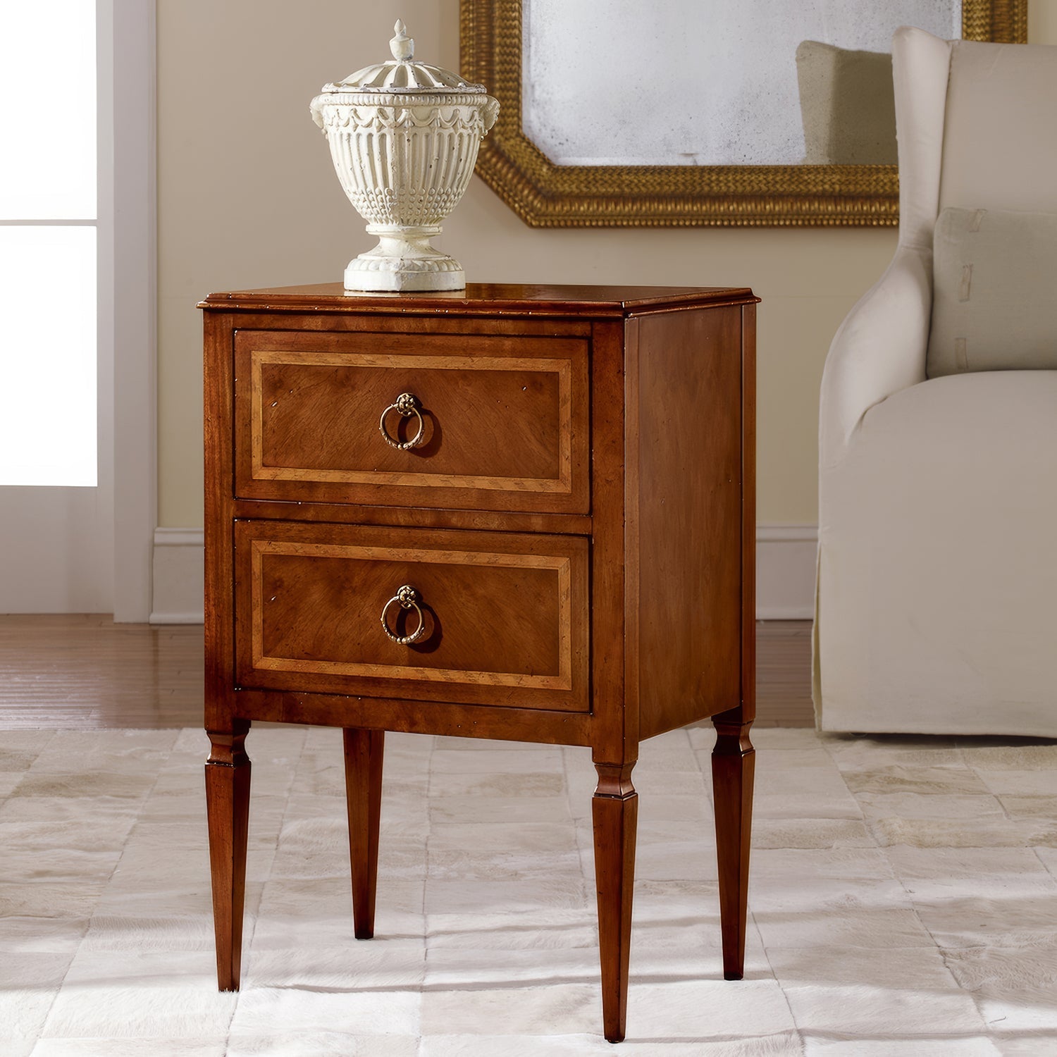 Italian walnut bedside chest with lamp on top.