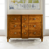 Italian walnut commode under modern art, in natural light.