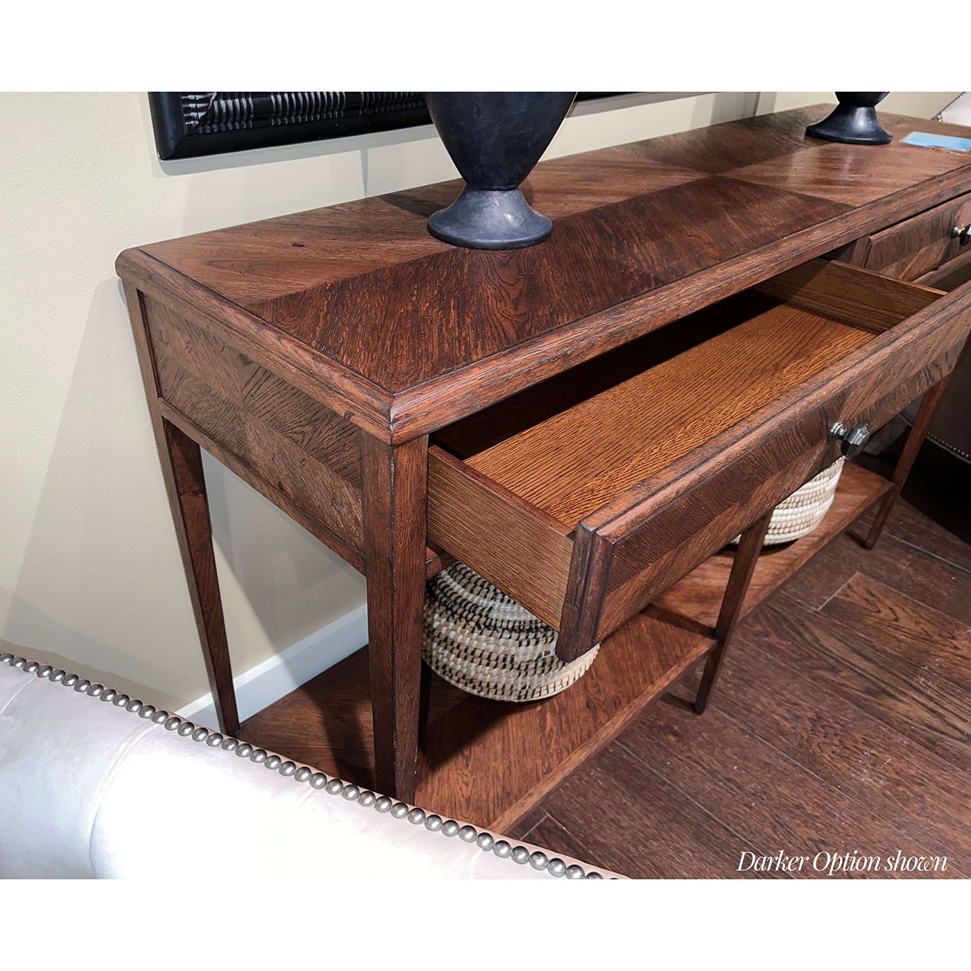 Open drawers of dark oak console table showing storage.