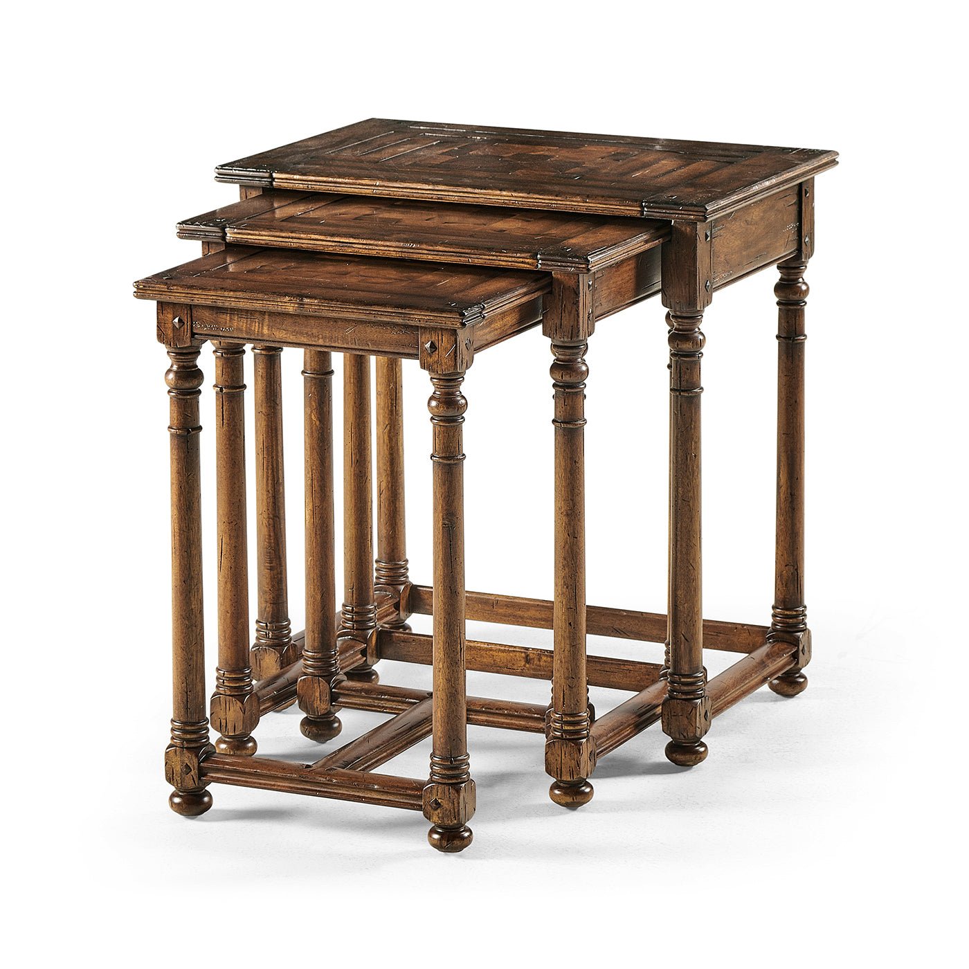 Three Jacobean style nesting tables stacked together.