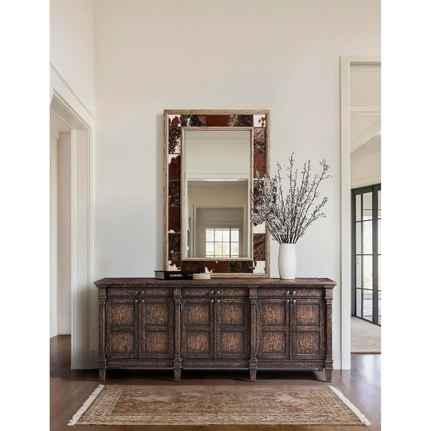 Sideboard in bright room with decorative mirror.