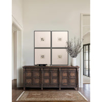 Wooden sideboard with framed art above, elegant setting.