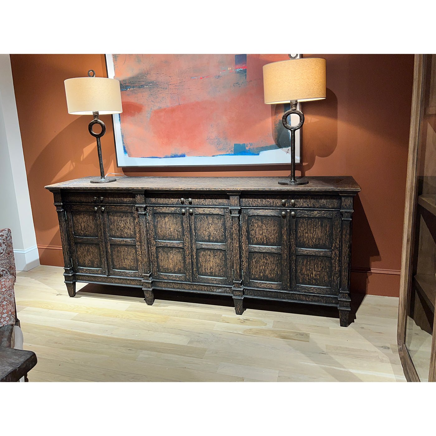 Sideboard with lamps and artwork, interior setting.