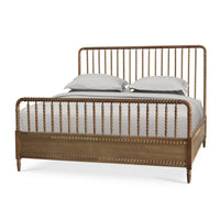 King size spindle bed frame with bedding, angled view.