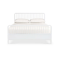 Front view of white spindle bed frame with pillows.