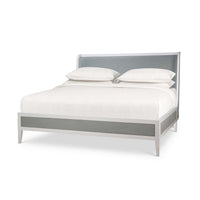 Angled view of king upholstered bed with linen wrap.