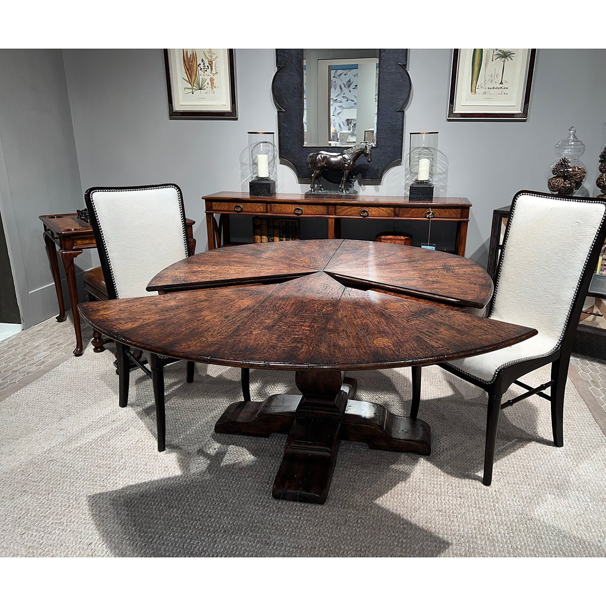 Dining table with extensions open, chairs around.