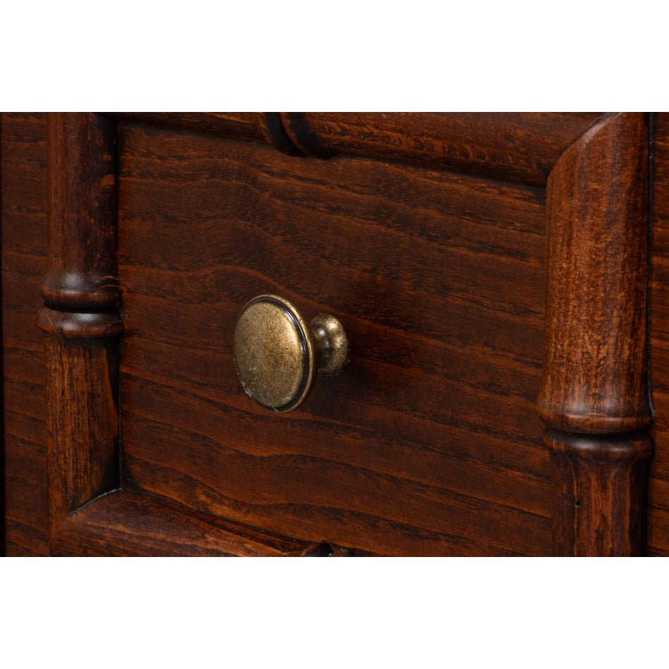 Close-up of brass knob on faux bamboo dresser drawer.