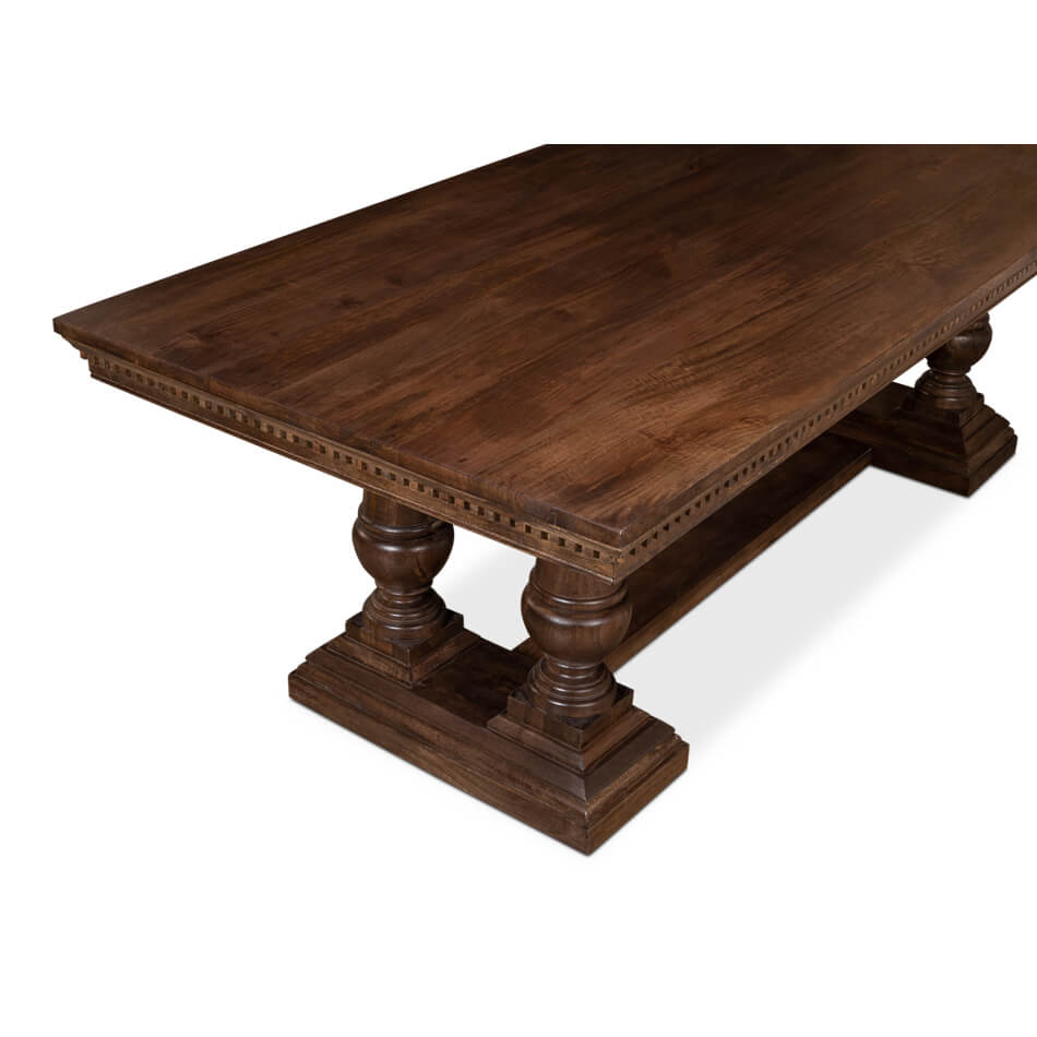 Angled view of dining table, robust pedestal legs shown.