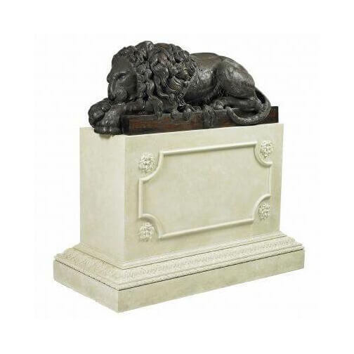 Bronze lion statue on white pedestal, decorative accessory.