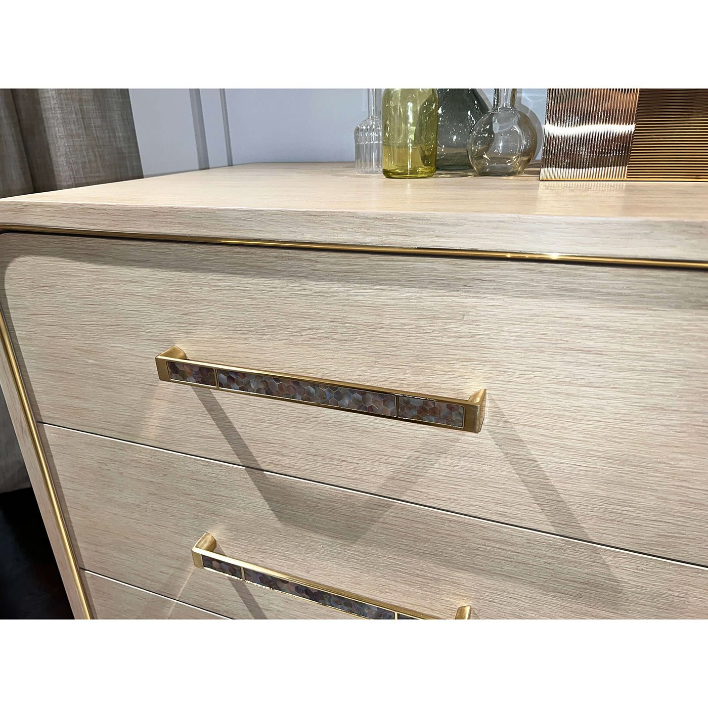 Close-up of dresser drawer handle, light finish.