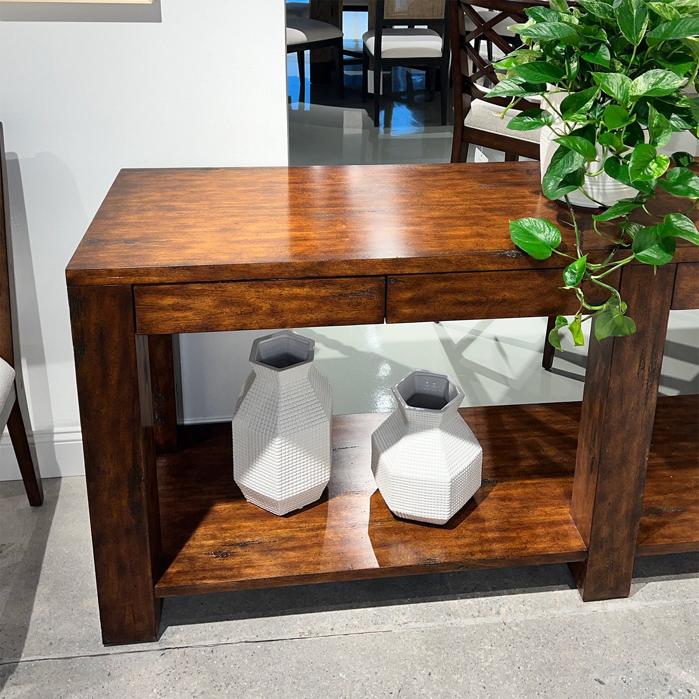 Console table with vases and potted plant.