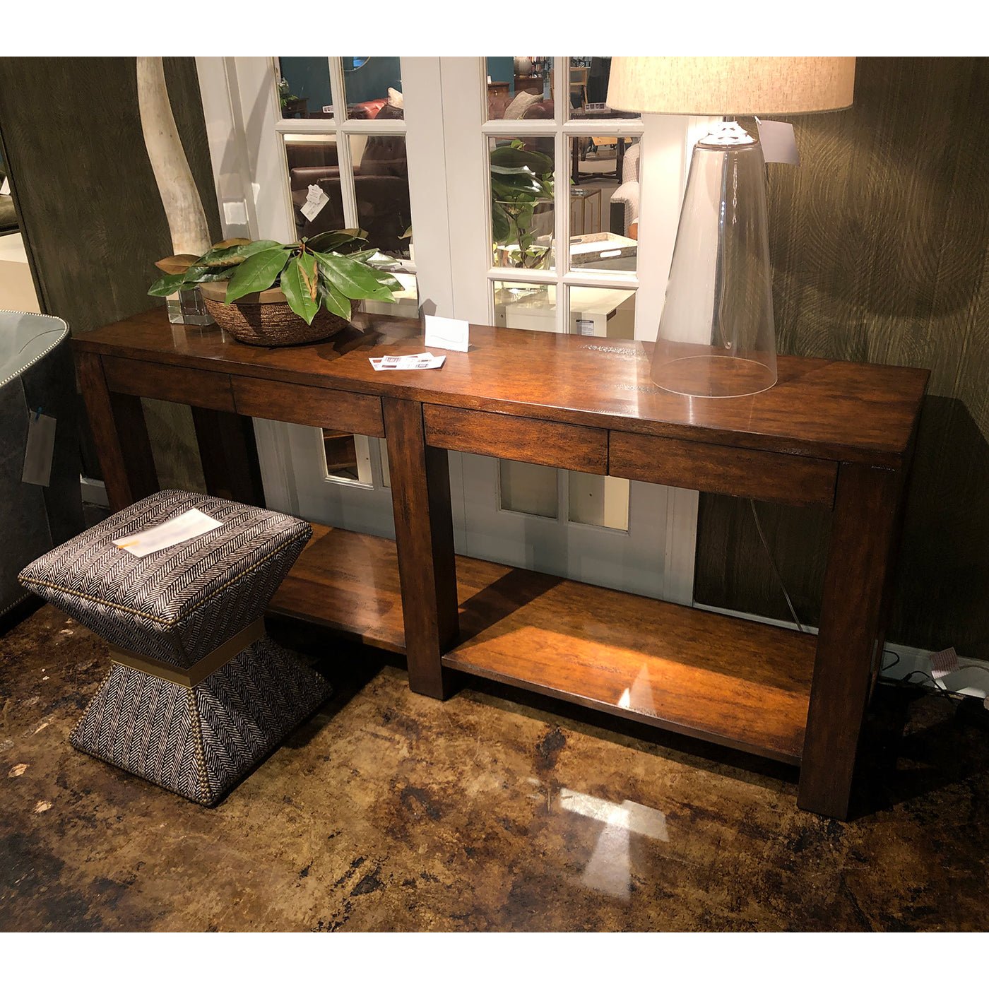 Console table with plants and lamp in living area.