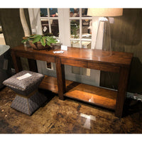 Console table with plants and lamp in living area.