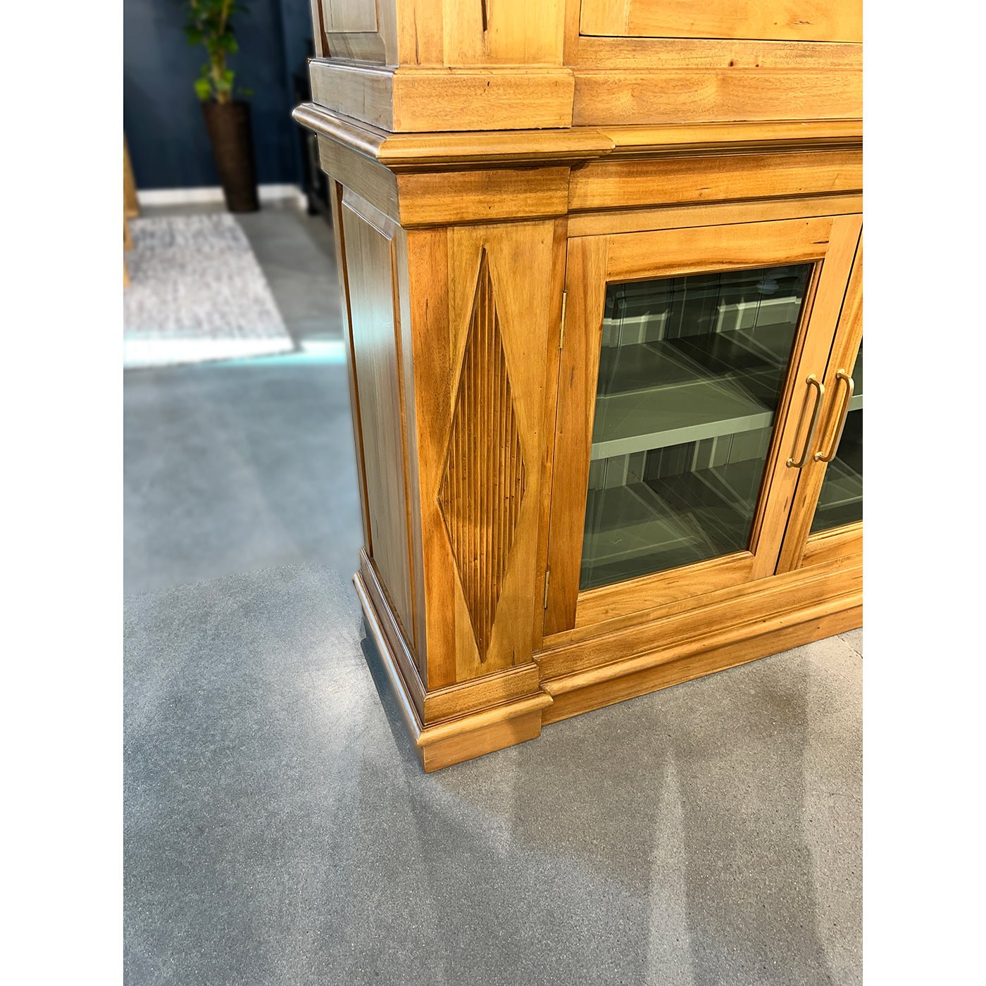 Base detail of bookcase with wood carving, showroom floor.